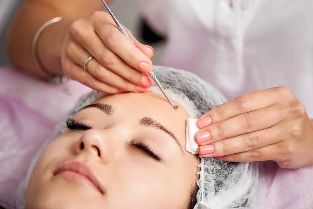 Esthetician preparing the forehead during facial care